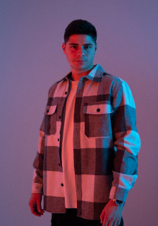 An upperbody portrait of my model in a studio with orange and purple lighting.