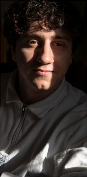 A portrait of one of my male models sitting with a deep contrast of light created by shadows.